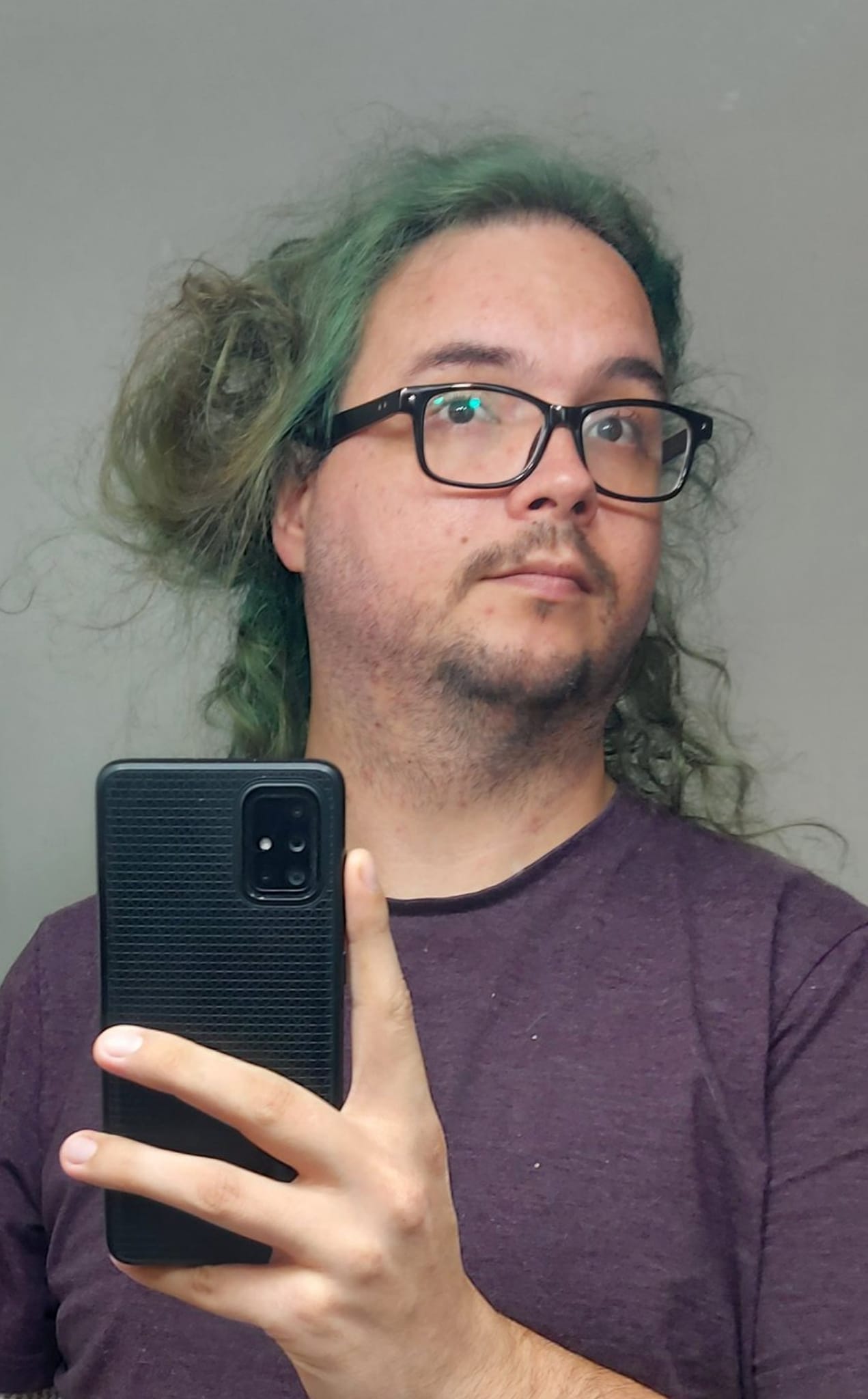 A man with long green hair and no beard is taking a mirror selfie, Photo 1